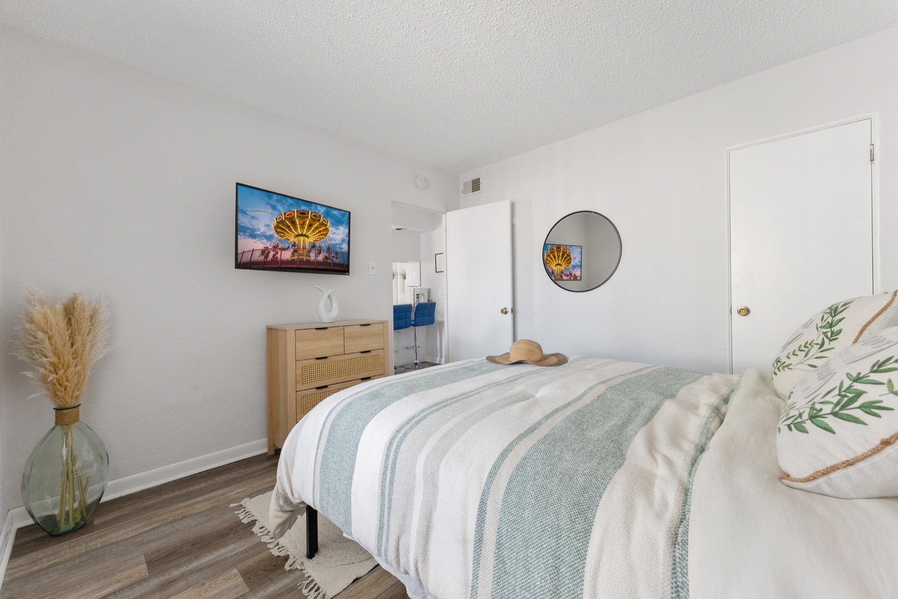 Queen bedroom with coastal decor and wall-mounted TV