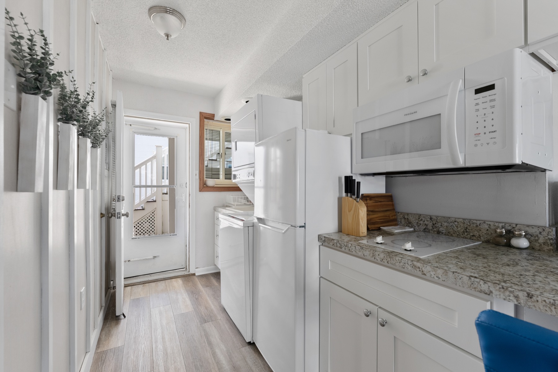 Kitchenette with refrigerator, microwave, stovetop, and laundry